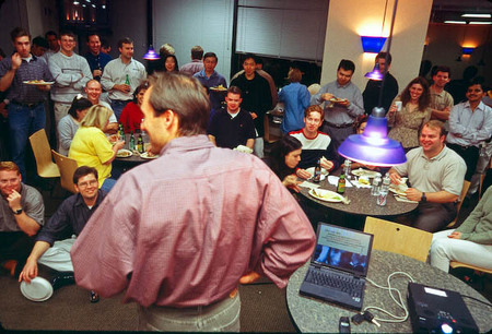 CEO Doug makes presentation while employees finish their dinner.